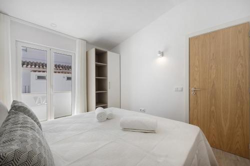 a white bedroom with a bed and a closet at Old Town Apartments Sea View in Lagos