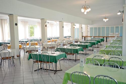 a dining room with green tables and chairs at Osrodek Rehabilitacyjno-Wypoczynkowy FAMA-STA in Mrzeżyno