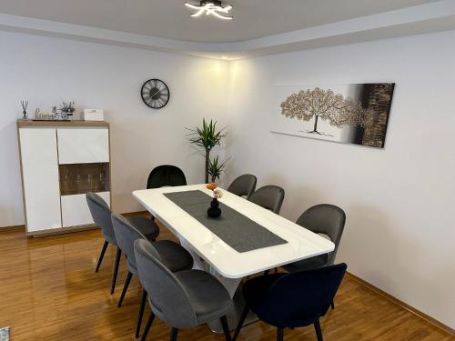 une salle à manger avec une table et des chaises blanches dans l'établissement Centar, à Krapina