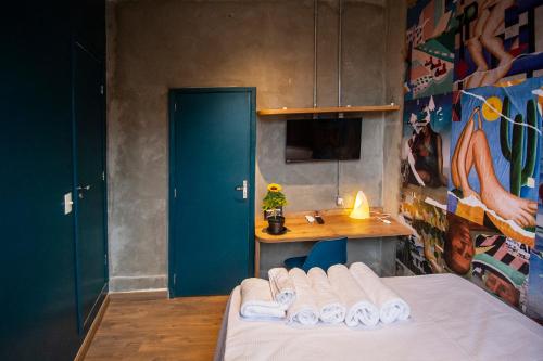 a room with a bed and a table with a blue door at Lobie Armazém São Joaquim in Rio de Janeiro