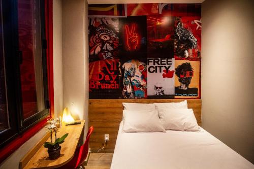 a bedroom with a bed and a table and posters at Lobie Armazém São Joaquim in Rio de Janeiro