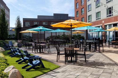 an outdoor patio with tables and chairs and umbrellas at Le Meridien Boston Cambridge in Cambridge