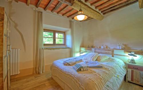 カスティリオーン・フィオレンティーノにあるPodere San Cassianoのベッドルーム(ベッド1台、窓付)