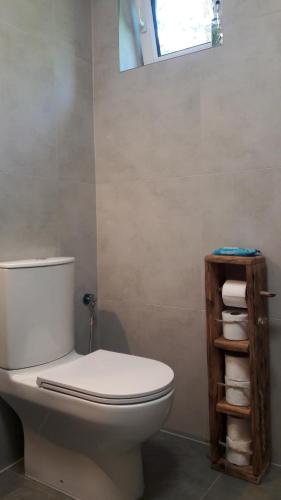 a bathroom with a toilet and a shelf with towels at Kofi Garden in Dębki