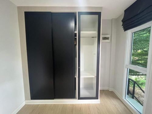 a black cabinet in a room with a window at The leaf mango tree in Kamphaeng Phet