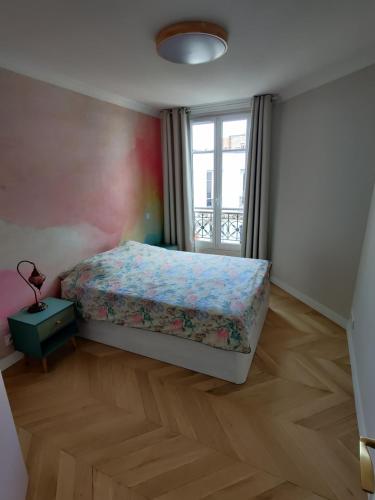 une chambre avec un lit et une fenêtre dans l'établissement Bel appartement 50 m2, à Paris