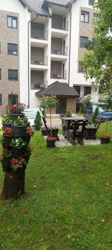 um parque com vasos de plantas e uma mesa de piquenique e um edifício em Šarm studio 301 em Zlatibor