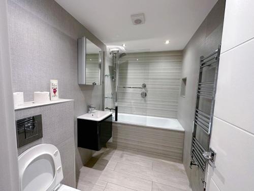 y baño con bañera, aseo y lavamanos. en Massive Flat Near Greenwich Park( with office), en Londres