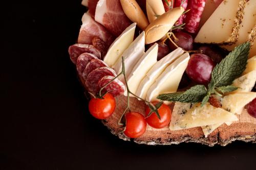 a plate of different types of cheese and tomatoes at Hotel Pax Guadalajara in Guadalajara