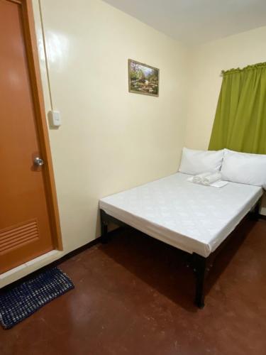 małe łóżko w narożniku pokoju w obiekcie ACHIEVERS DORMITORY w Cebu