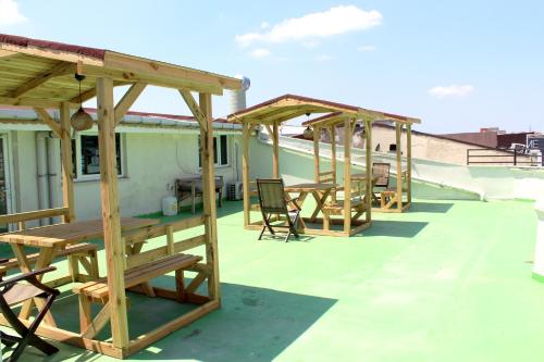 a row of wooden tables and chairs on a roof at White Crown Apartman ve Yaşam Merkezi in Istanbul