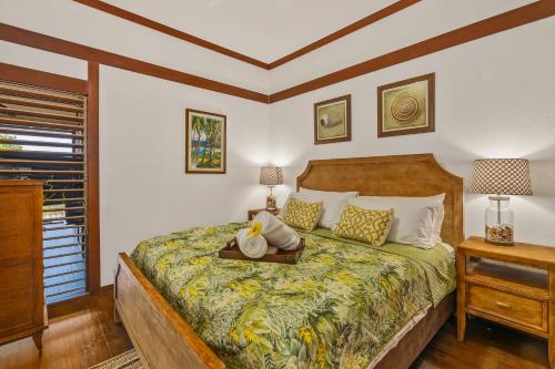 a bedroom with a bed and two lamps and a window at Beautiful Poipu AC, Walk to Beach, Pool and Tennis KP117 in Koloa