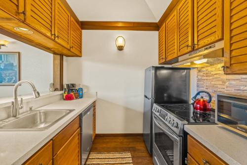 a kitchen with a stainless steel stove and a sink at Beautiful Poipu AC, Walk to Beach, Pool and Tennis KP117 in Koloa