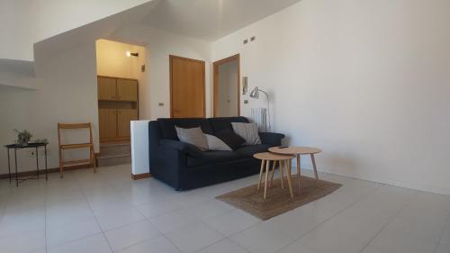 ein Wohnzimmer mit einem blauen Sofa und einem Tisch in der Unterkunft Comodo per Venezia - Schissa apartment in Jesolo