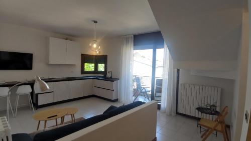 ein Wohnzimmer mit einem blauen Sofa und einer Küche in der Unterkunft Comodo per Venezia - Schissa apartment in Jesolo