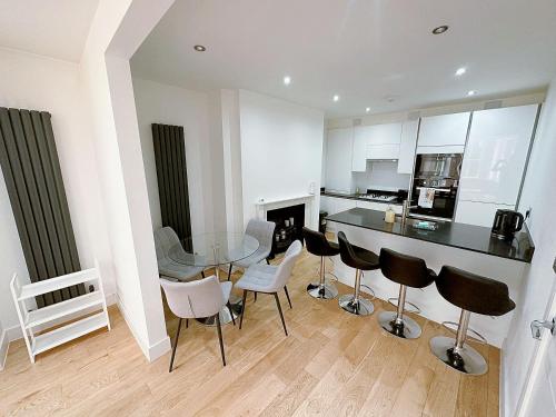 a kitchen with a glass table and chairs at Massive Flat Near Greenwich Park( with office) in London