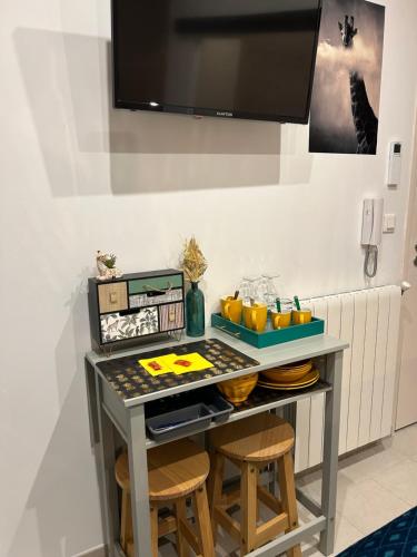 une table avec deux tabourets dans une pièce dans l'établissement LA MADDYSON, à Narbonne