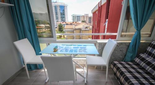 a table and chairs in a room with a window at Irena Downtown Apartment in Budva