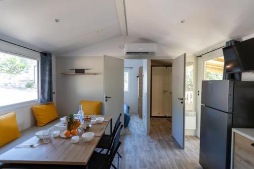 een eetkamer en een keuken met een tafel en een koelkast bij Camping Le Damier in Pianottoli-Caldarello