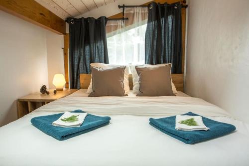 um quarto com uma cama com toalhas azuis em Ocean Garden Surf Lodge em Capbreton