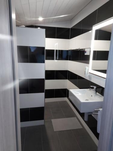 a black and white bathroom with a sink and a mirror at good bed Bettenhausen in Oberönz