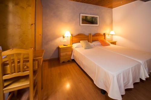 een slaapkamer met een groot wit bed en een stoel bij Hotel Ca L'amagat in Bagá