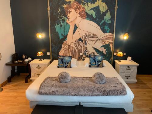 een slaapkamer met een bed met een schilderij aan de muur bij Hôtel Vintage in Quimperlé