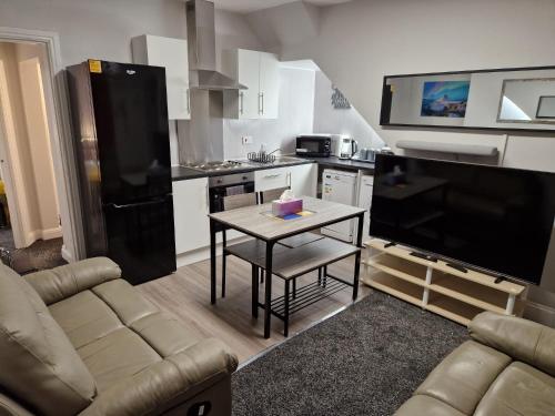 a living room with a couch and a table in a kitchen at Chester Le Street's Emerald 3 Bed House in Chester-le-Street