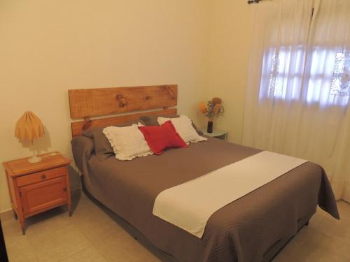 a bedroom with a bed with a wooden headboard and a night stand at La casita de Cerrillos in Salta