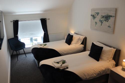 a hotel room with two beds and a window at Sandbach Apartments in Sandbach