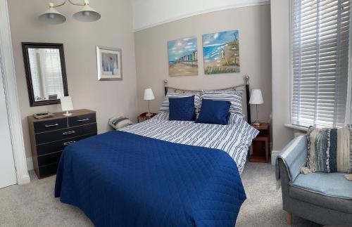 - une chambre avec un lit bleu et une chaise bleue dans l'établissement Self contained Garden Flat newly Refurbished, à Bridlington