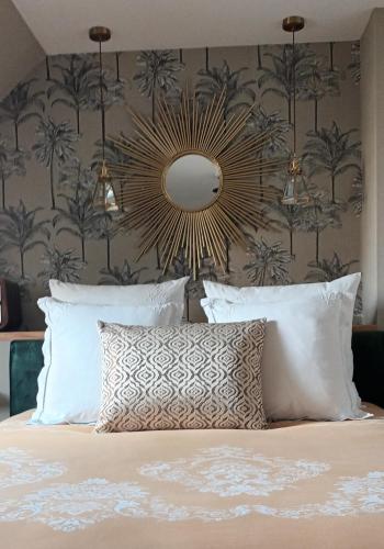 - une chambre avec un lit et un mur orné de palmiers dans l'établissement Maison 1949, à Saint-Sauveur-le-Vicomte