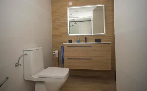 uma casa de banho com um WC branco e um espelho. em Topacio 3 en prim43ra linea de la playa en Calpe con Buenas vistas em Calpe