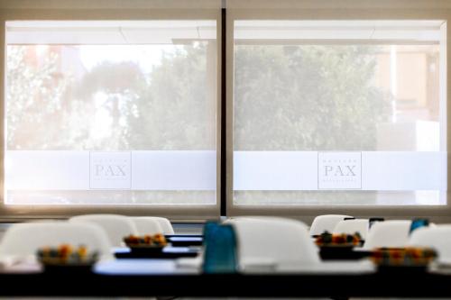 a table and chairs in front of two windows at Hotel Pax Guadalajara in Guadalajara