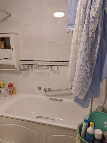 a bath tub in a bathroom with a curtain at Luxury 5 bedroom home near London Seven Kings Train station- 5 Room, 6 bed and sleeps 8 guest in London