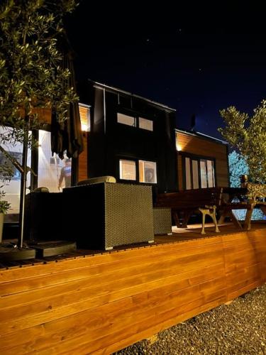 une maison noire sur une terrasse en bois la nuit dans l'établissement Secret Tiny Houses, à Mudanya