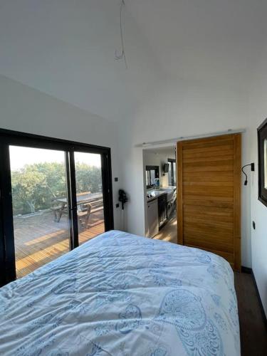 1 dormitorio con 1 cama y puerta corredera de cristal en Secret Tiny Houses, en Mudanya