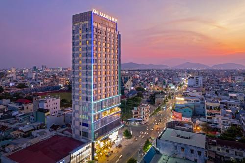 Ein hohes Gebäude mit einem Schild in einer Stadt. in der Unterkunft G8 Luxury Hotel and Spa Da Nang in Đà Nẵng