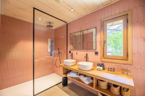 a pink bathroom with two sinks and a window at Hôtel du Domaine Casanghjulina in Porto-Vecchio