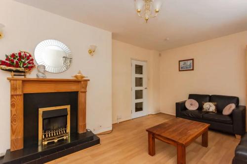 a living room with a fireplace and a couch at Homely 3 Bedroom House with a Garden in London