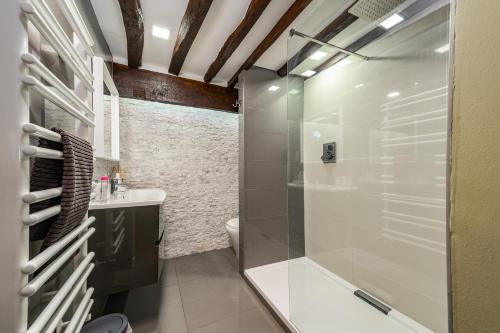 y baño con ducha, aseo y lavamanos. en Spacious, luxury town centre Granary conversion, en Stamford