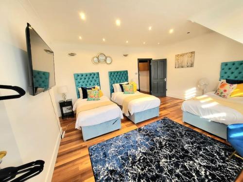 a large room with two beds and a rug at Spacious Six Bedrooms House By Sensational Stay Short Lets & Serviced Accommodation With 13 Beds, Free Parking, Free Wi-fi & Balcony in London