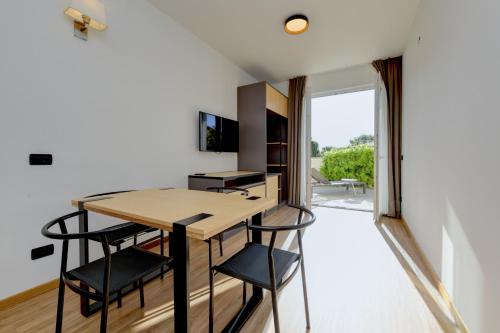 a small kitchen with a wooden table and black stools at Hotel Arya by Mauro in Sirmione