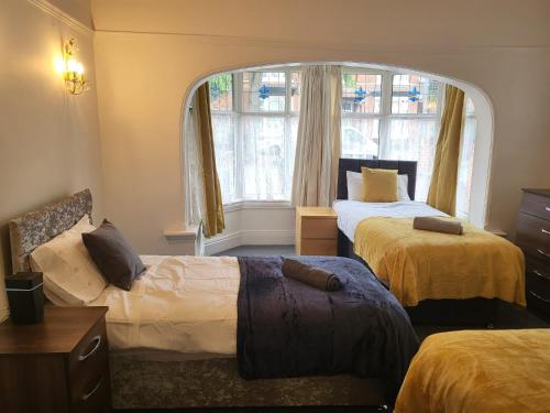 sypialnia z 2 łóżkami i dużym oknem w obiekcie MM Short Stays w Birmingham