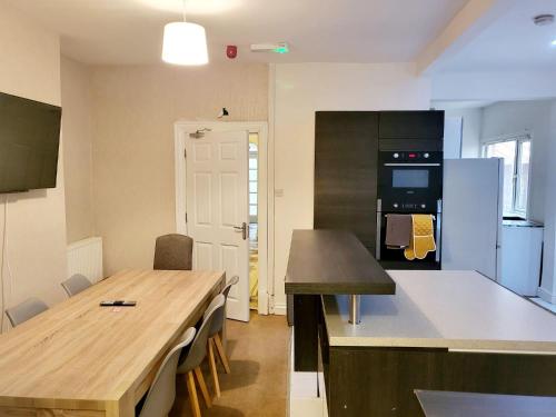 uma cozinha com uma mesa de madeira e uma cozinha com um balcão em MM Short Stays em Birmingham