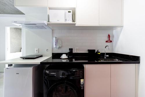 a kitchen with a washer and a white counter top at Xtay São Paulo BK30 Santana in São Paulo