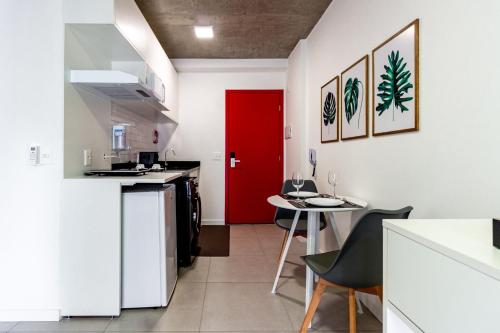 a kitchen with a red door and a table at Xtay São Paulo BK30 Santana in São Paulo