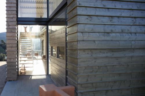 a wooden house with a glass facade at Mas Vivent in Vilamaniscle
