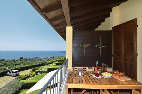 a wooden table on the balcony of a house at BBQ & Pools GHH in Toscolano Maderno