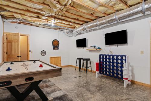 a room with a ping pong table and a tv at Deer Run Retreat in Ellijay